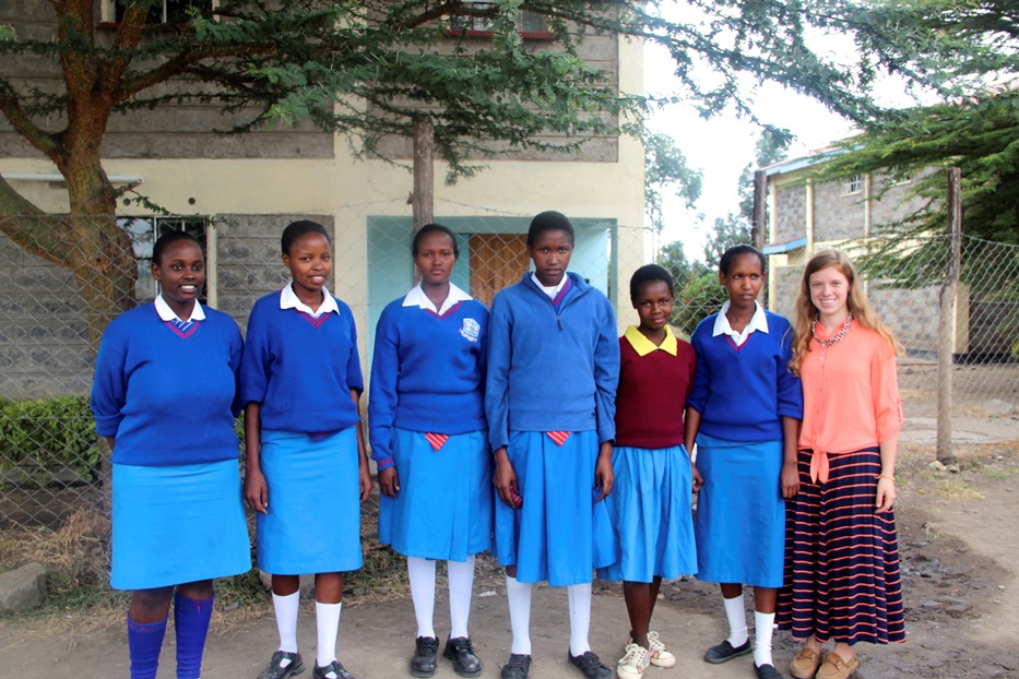 Mary Grave posing with some of the girls who benefit from her work.